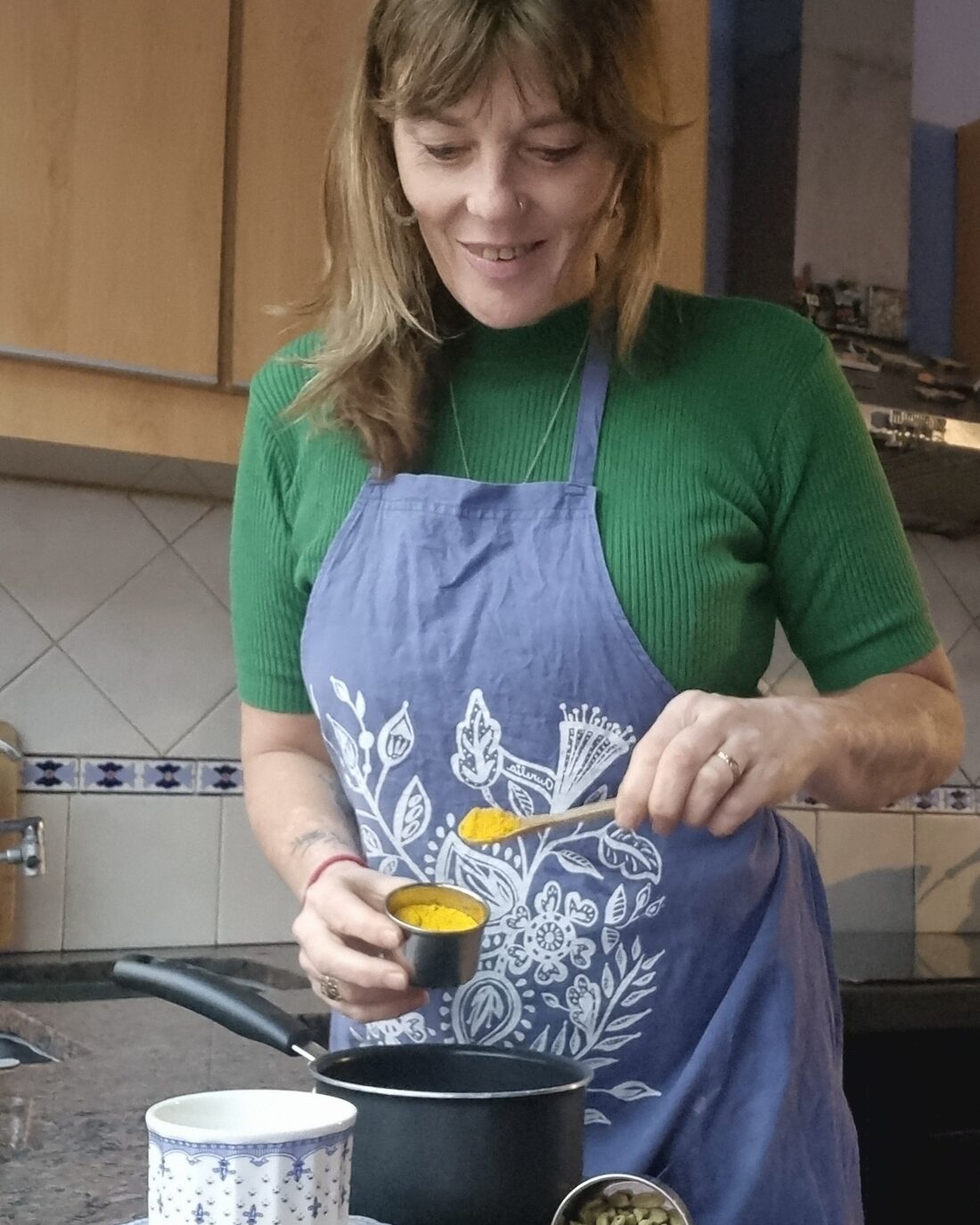 Sandra De Martin midiendo cúrcuma durante un taller de cocina.